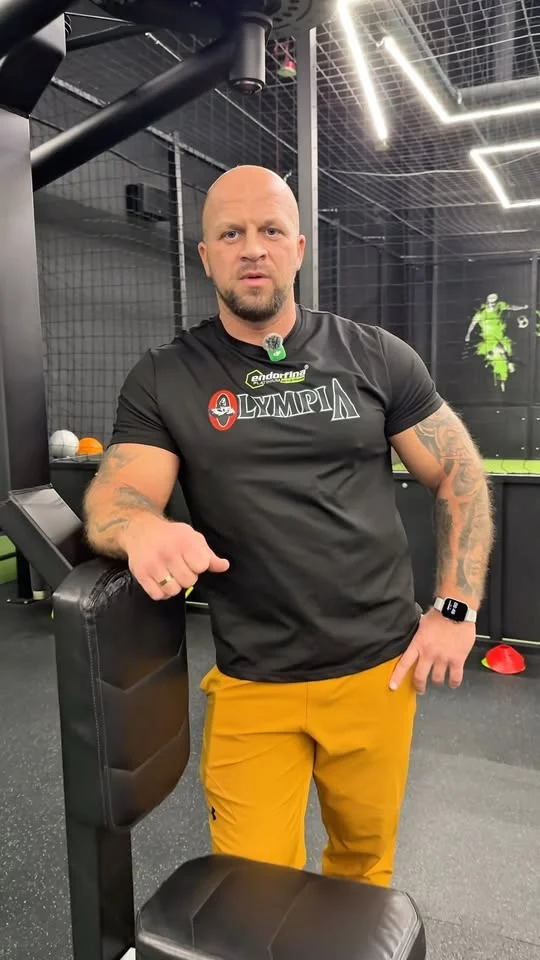 Rafał Bratowski opiera się o maszynę na siłowni